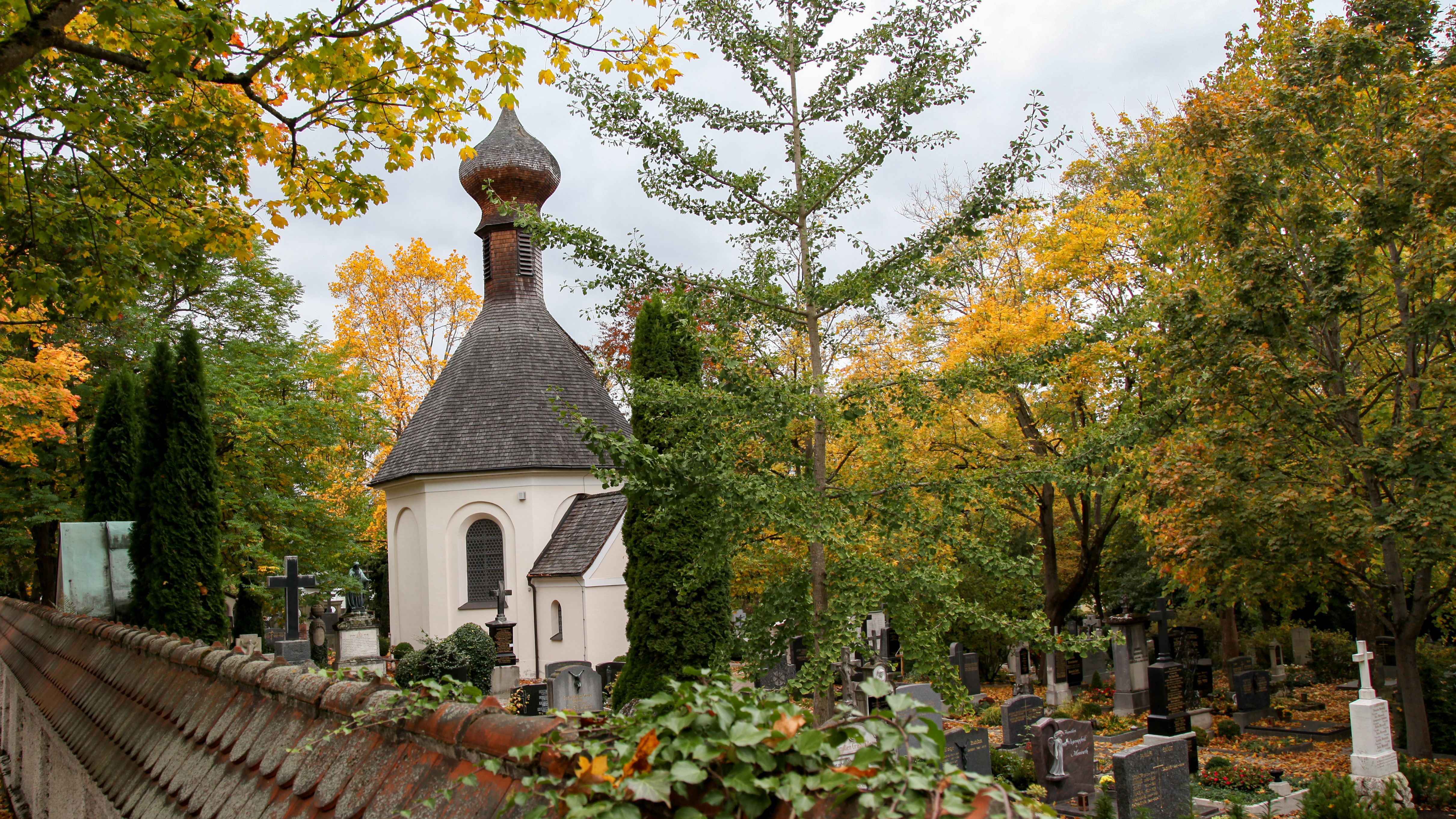 Old cemetery Dachau: Chapel and graves under big trees with fall leef colours. Photo: City of Dachau